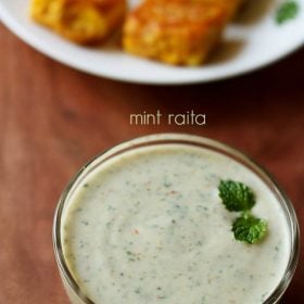 mint raita garnished with a mint sprig and served in a glass bowl with text layover.