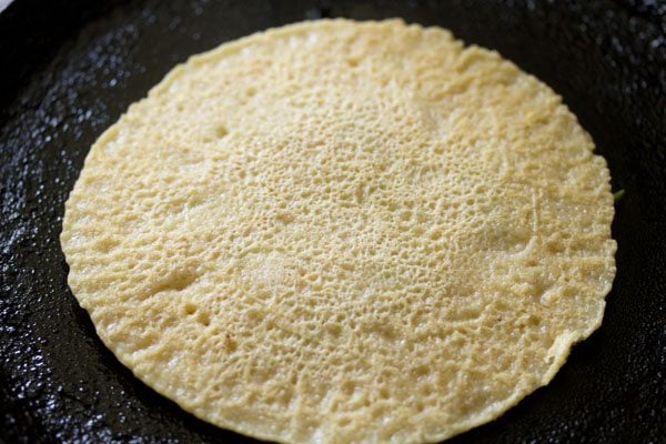 cooking veggie side of oats uttapam. 