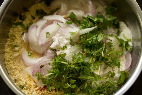 thinly sliced onions, chopped coriander leaves, chopped curry leaves, chopped green chilies and salt added to flour mixture. 