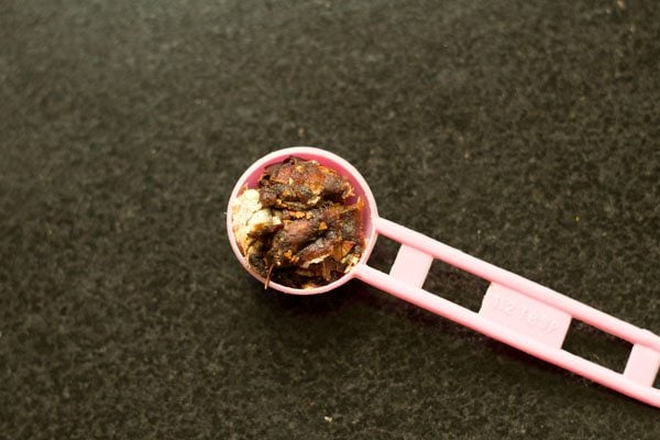 tightly packed tamarind in a spoon for making pepper rasam. 