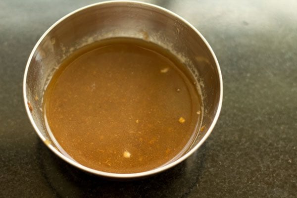 pulp squeezed from soaked tamarind in a bowl for making pepper rasam. 