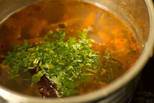 chopped coriander leaves added to cooked milagu rasam. 