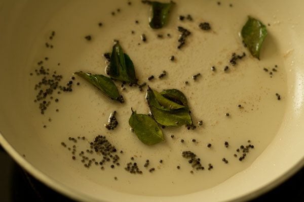 mixing curry leaves with mustard seeds