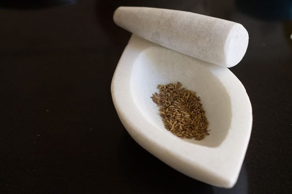 roasted cumin seeds in a mortar.
