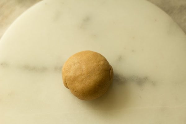 dough piece rolled and placed on rolling board. 