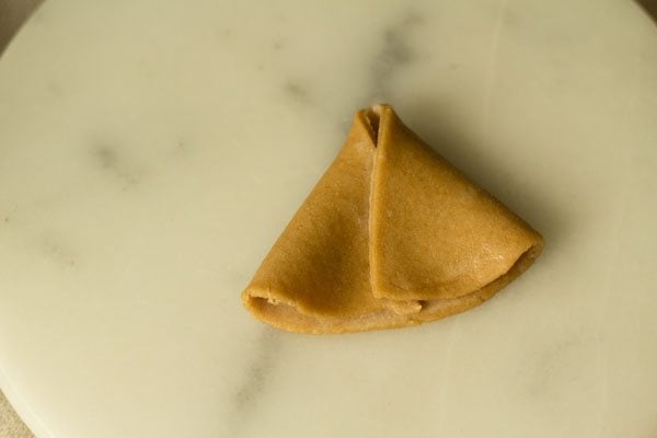 shaping the pastry disc into a cone. 