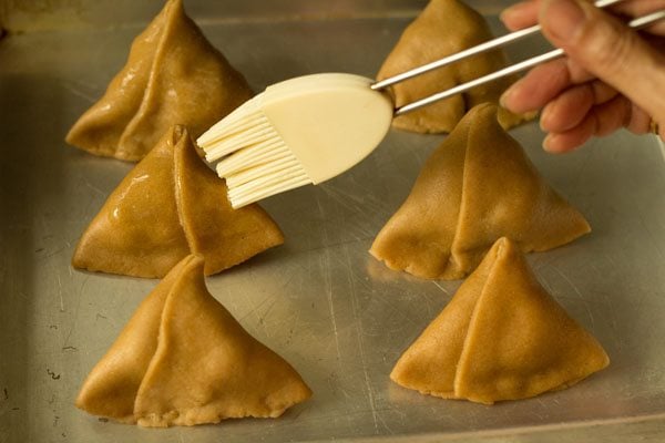 brushing samosas with oil. 