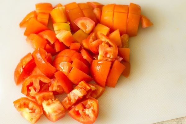 chopped tomatoes on a white chopping board