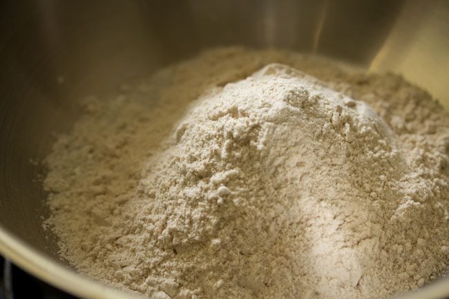 whole wheat flour added to a thick bottomed pan for atta laddu. 