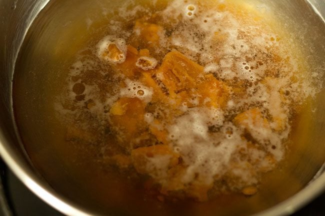chopped jaggery added to a pan of water for sweet appam.