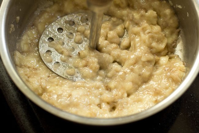 mashing chopped bananas with a masher. 