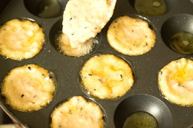 adding prepared sweet appam batter in each mould. 