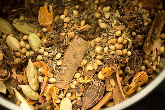 sun dried whole spices added to a grinder jar. 