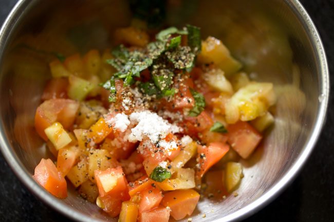 salt added to bowl with tomatoes.