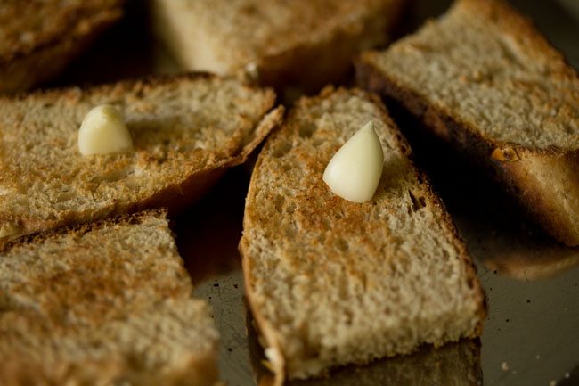 rubbing raw garlic clove on the toasted bread. 