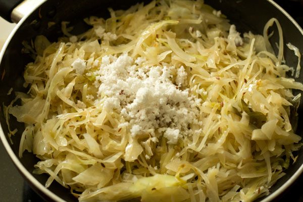 adding coconut to cabbage bhaji