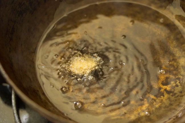 small portion of vada mixture getting fried in oil
