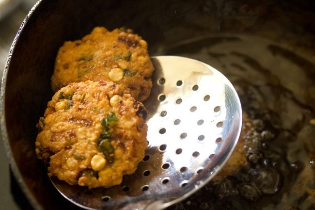 parippu vada on a slotted spoon