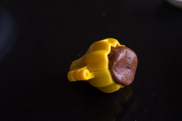 chocolate mixture ball placed inside modak mould