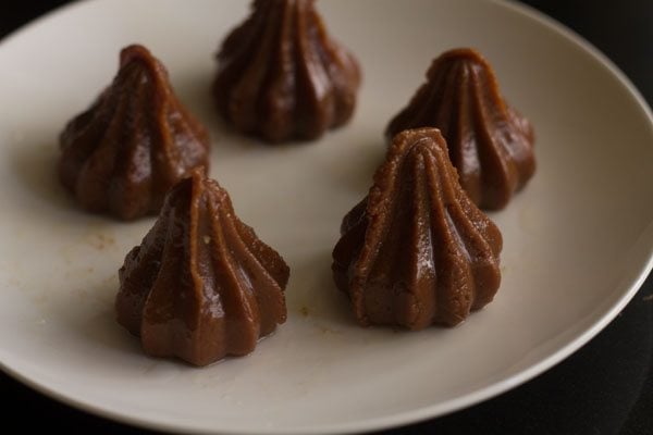 chocolate modaks placed over a greased plate