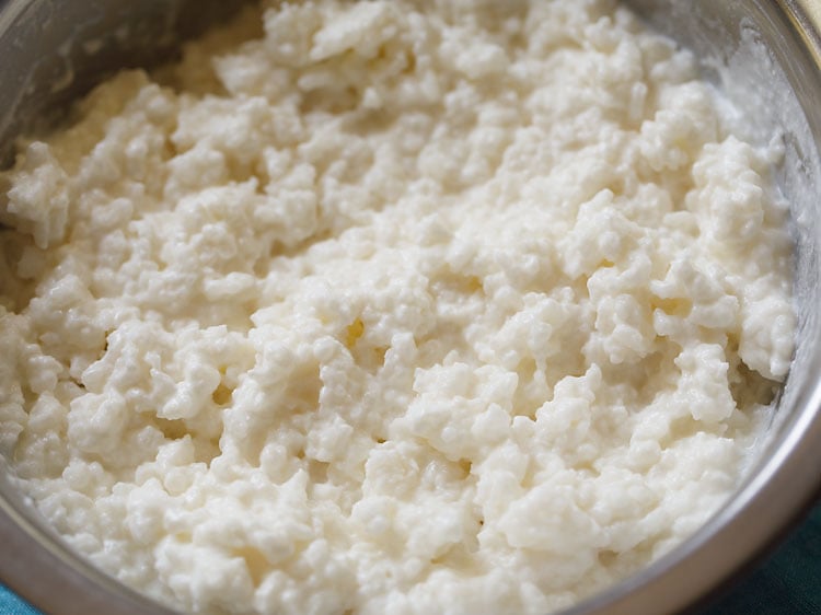 mixing rice with curd and milk to make thayir sadam.