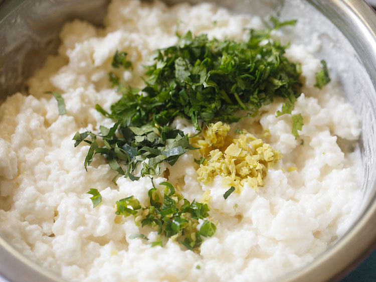 adding chopped coriander leaves, chopped green chilies, chopped curry leaves and chopped ginger in the curd rice mixture.
