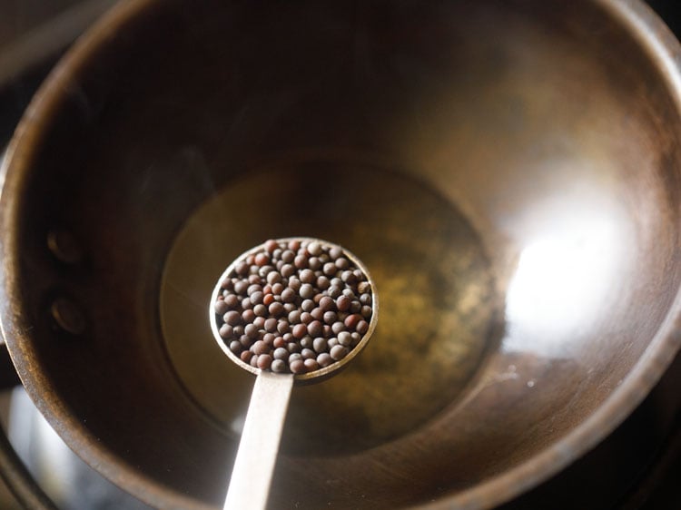 adding mustard seeds in hot sesame oil. 