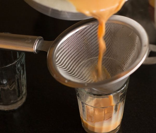 pouring cutting chai into glasses