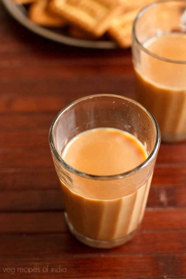 cutting chai served in glasses along with biscuits