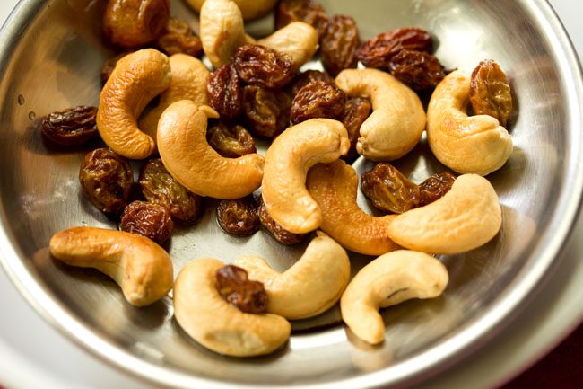fried cashews and raisins kept on a steel plate