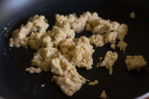 frying grated khoya in a hot pan. 