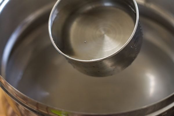 adding water in a steamer pan. 