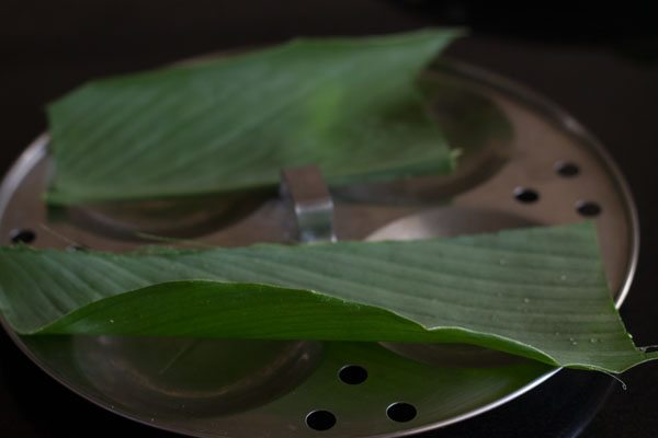 turmeric leaves placed on idli mould. 