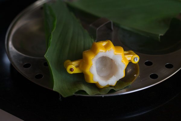 making a cavity in the center of the dough in the modak mould. 