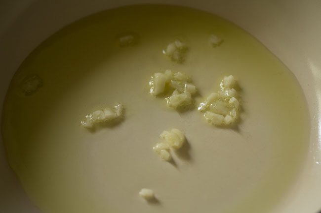 sautéing chopped garlic in hot olive oil in pan. 