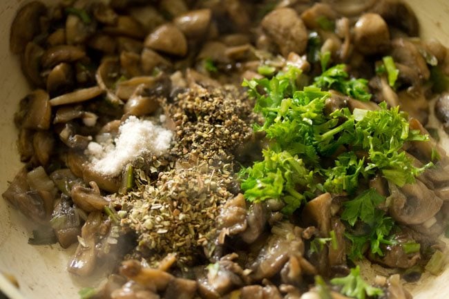 dried oregano, crushed black pepper and chopped parsley added to the mushrooms in the pan. 