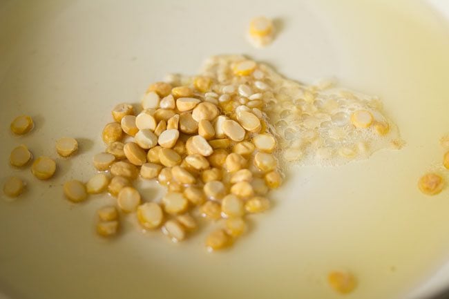 oil, chana dal (bengal gram) and urad dal (split and husked black gram) in a pan