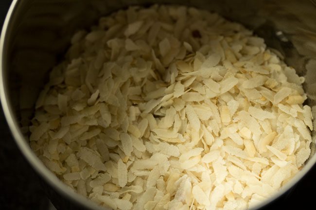 roasted poha added to a grinder jar for making poha laddu. 