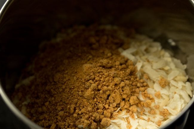 Jaggery powder is added to the grinder bowl. 