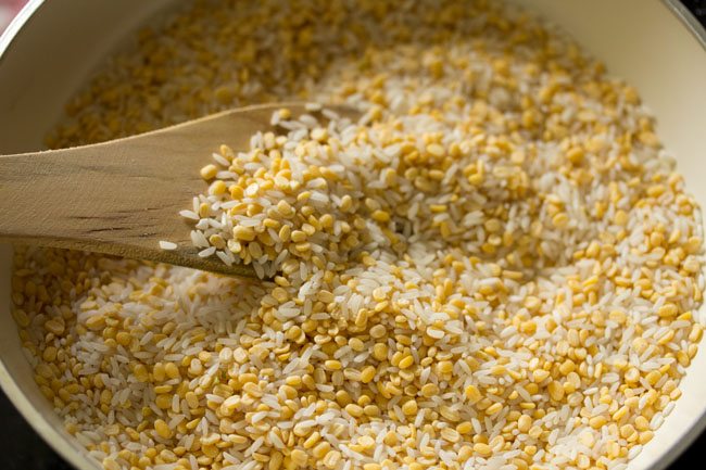 roasting dal and rice with a wooden spatula