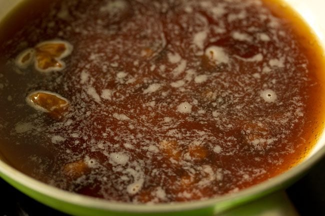 amber brown colored jaggery liquid being simmered