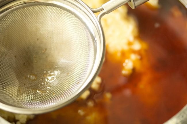 jaggery solution strained with a strainer into the cooked rice and lentils