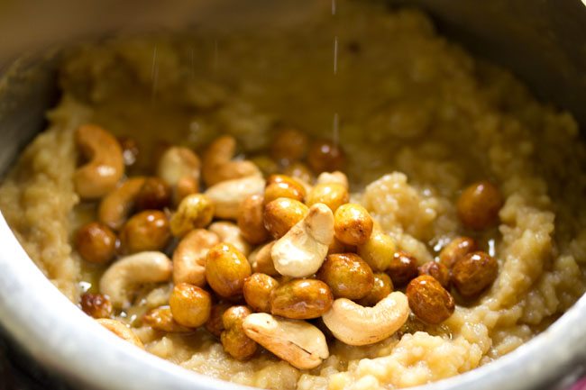 fried mixture of raisins, cashews and ghee on the mashed rice and lentils mixture