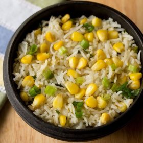corn fried rice served in a black bowl.