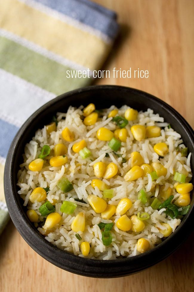 corn fried rice served in a black bowl with text layovers.