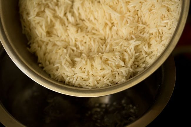 adding drained rice to the boiling water. 