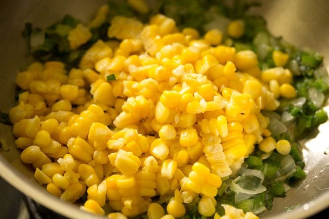 steamed corn kernels added to the wok. 