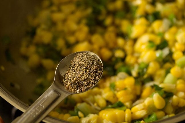 adding crushed black pepper to the corn mixture. 