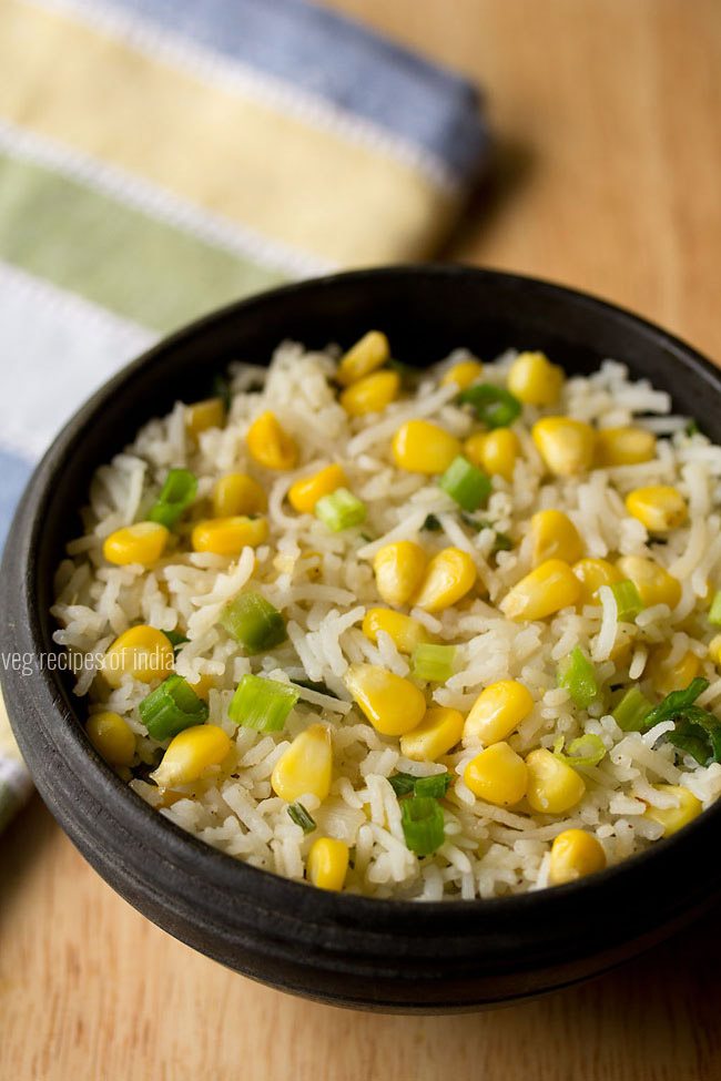 corn fried rice served in a black bowl with text layover. 