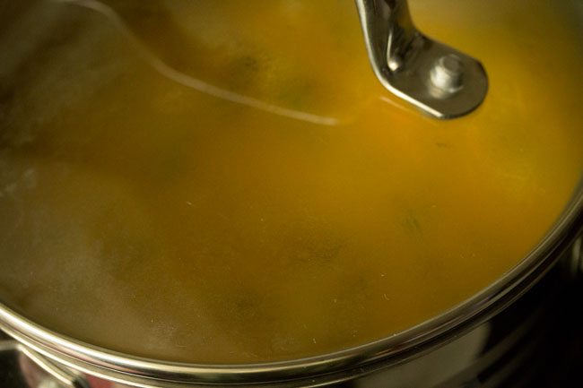 cooking tomato biryani in a closed pan